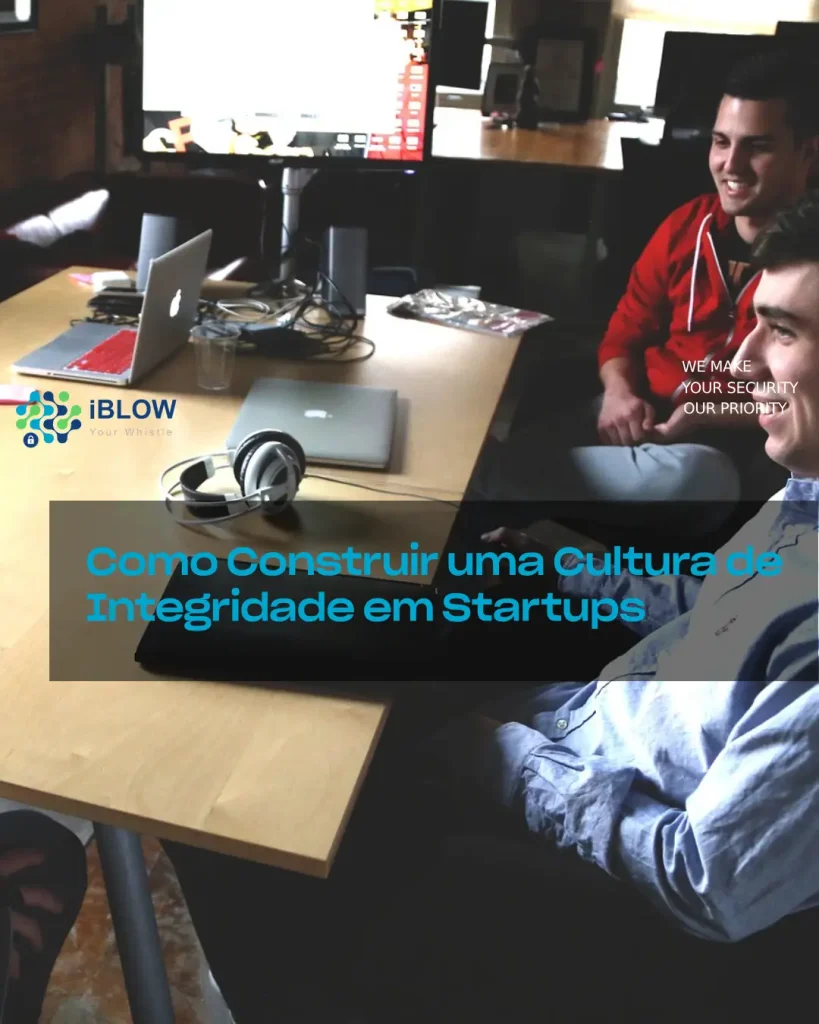 Reunião de empresa startup com 2 empreendedores reunidos numa mesa com portáteis e headphones, em artigo iBlow.eu Como Construir uma Cultura de Integridade em Startups