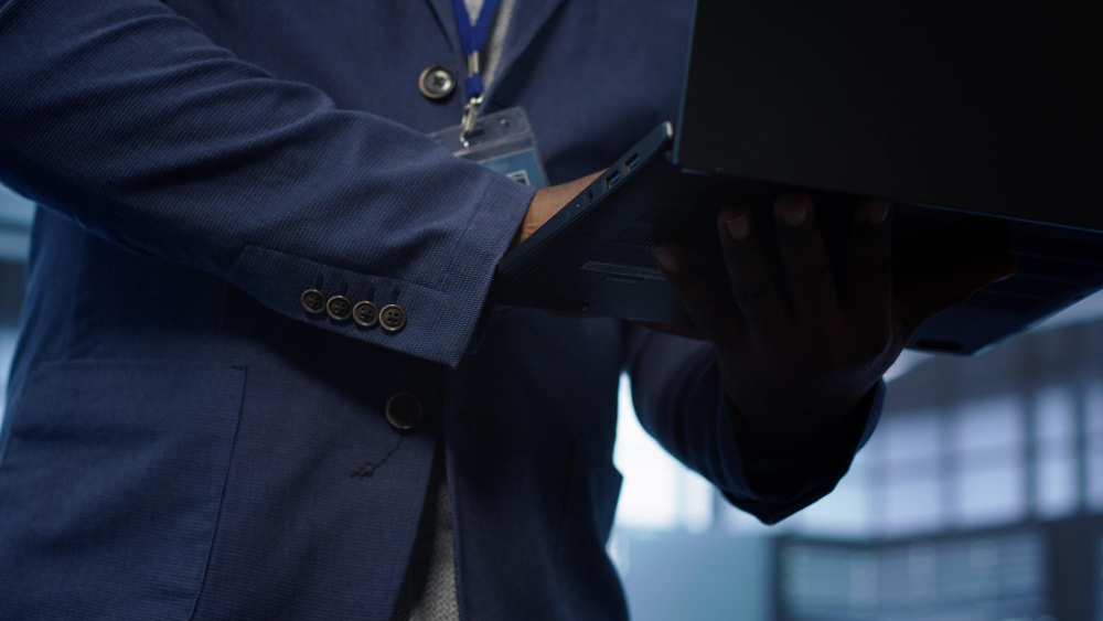 Pessoa segurando um computador portátil de fato